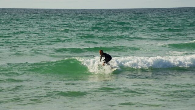 Professional surfer riding and catching waves in ocean