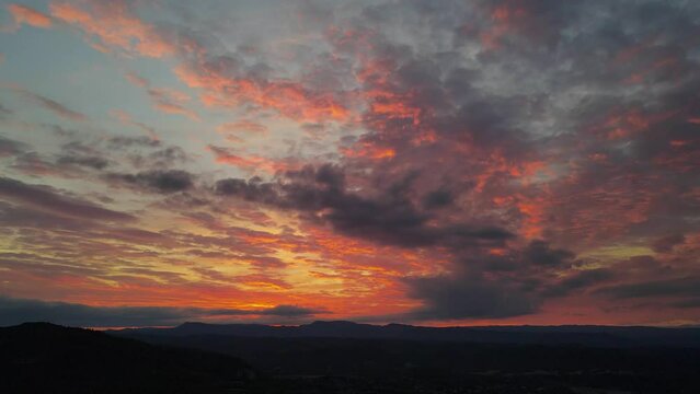 Scenic footage of the colorful sky and clouds over the mountains on a quiet day