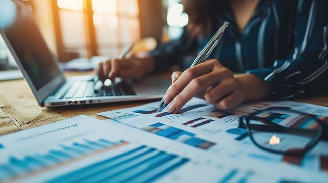 Hands of businesswoman examining graph at desk,Financial advisor and accounting concept