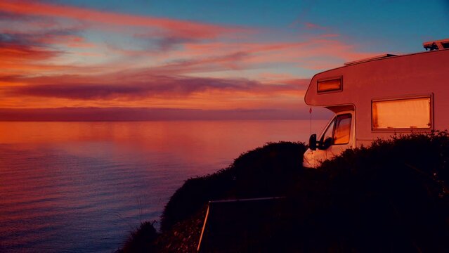 Camper rv camping on beach sea shore at sunrise. Adventure, travel with mobile home to Spain in wintertime.