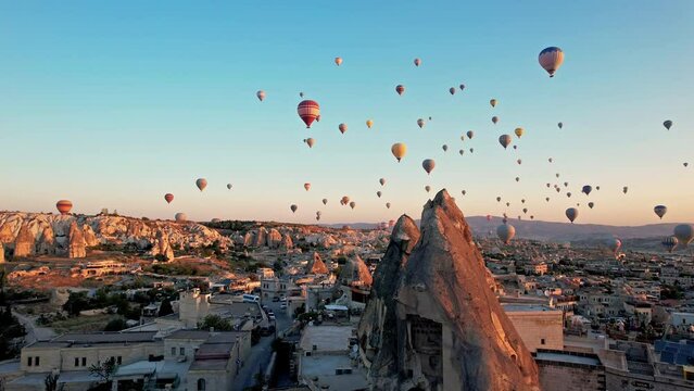 Hot air balloons in cappadocia at sunrise, fly in the sky over a mountain valley Aerial view. The vibrant balloons rise gracefully over the valley, Goreme. Enchanting spectacle of a hot air balloon