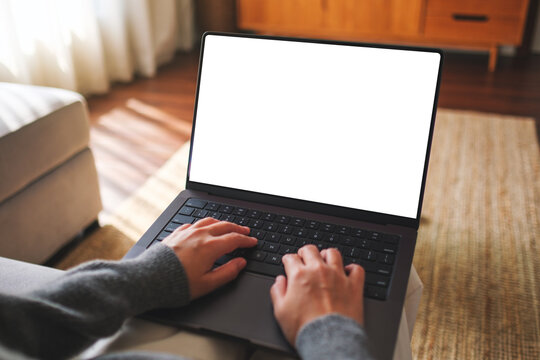 Mockup image of a woman working and typing on laptop computer with blank white desktop screen at home