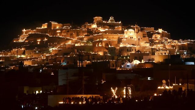 Santorini island, Greece. Easter Good Friday celebrations in Pyrgos village, Santorini, Greece. Candles with fire on the rooftops of the houses. Traditional orthodox easter in Greece