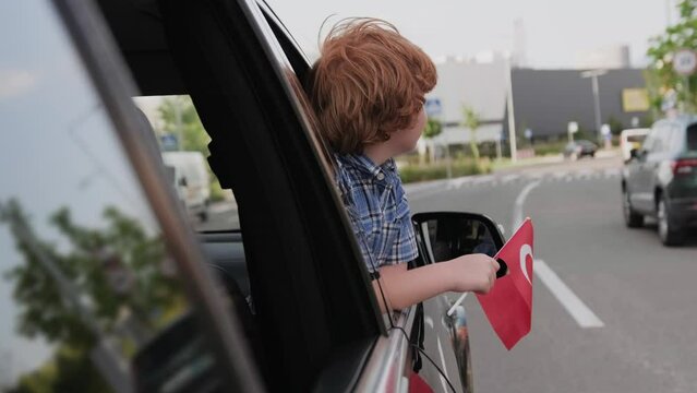 Little boy holding Turkey flag in the car. Slow motion