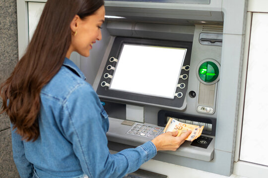 Woman withdrawing Euro cash at ATM machine outside, lady bank client taking banknotes, making financial transactions