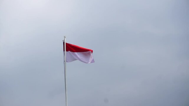 the Indonesian flag flying on a pole