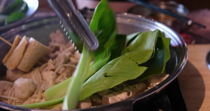 lid of a bubbling pot with broth boiling beneath, on a modern induction stove in a cozy kitchen. AI generative