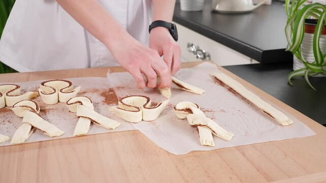 Easter baking is being prepared in the kitchen, a girl makes Easter bunnies and rabbits from dough. Homemade aromatic baking, Easter food, festive pie, Easter holiday, front view, close-up.