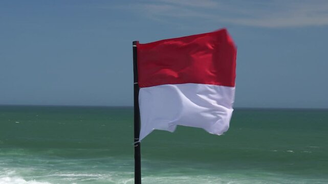 Indonesian country flag flutters in the wind sea breeze, placed by the Drini beach in Yogyakarta.