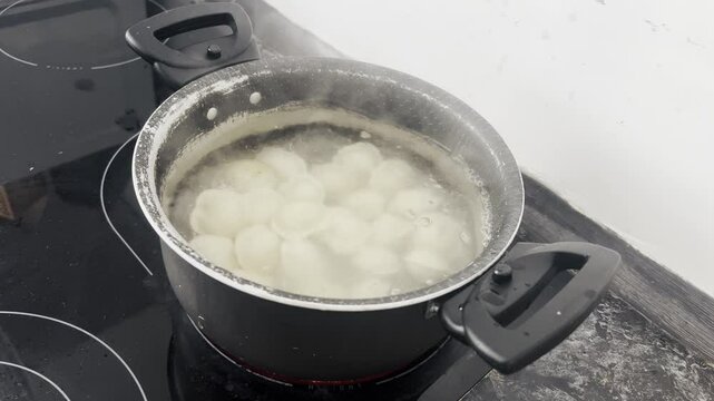 Fresh dumplings are poured into boiling water for cooking. Cooking at home.