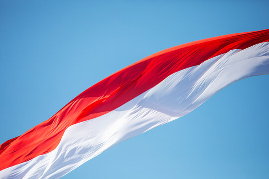 Polish flag waving in the wind against a blue sky.