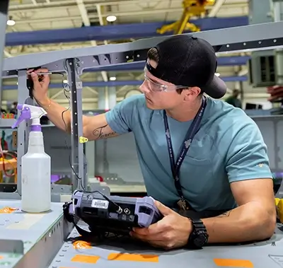 young male engineer wearing safety goggles and working on a project