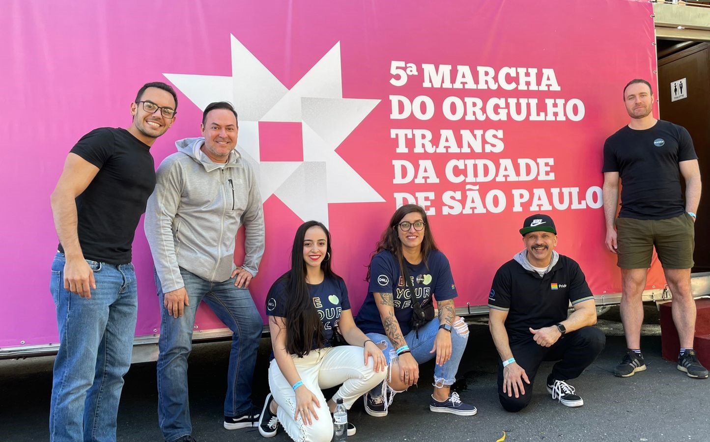 Marina poses in front of a sign with a group of people.