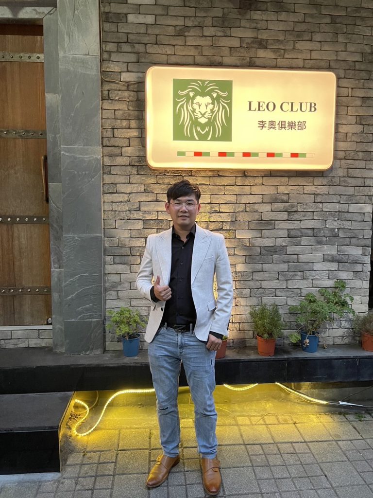 吳霆易在李奧俱樂部門口前展示親手設計的品牌設計(LOGO)。（圖/記者 張泓笙翻攝）