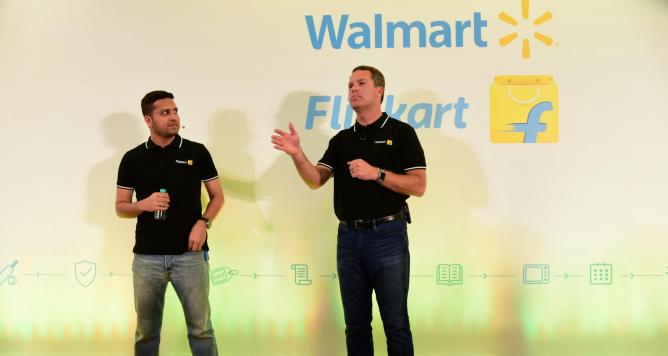 Walmart CEO Doug McMillon (R) speaking next to Flipkart co-founder and CEO Binny Bansal at an event in Bangalore