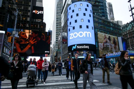 NEW YORK, NY - APRIL 18: People pass walk by the Nasdaq building as the screen shows the logo of the video-conferencing software company Zoom after the opening bell ceremony on April 18, 2019 in New York City. The video-conferencing software company announced it's IPO priced at $36 per share, at an estimated value of $9.2 billion. (Photo by Kena Betancur/Getty Images)