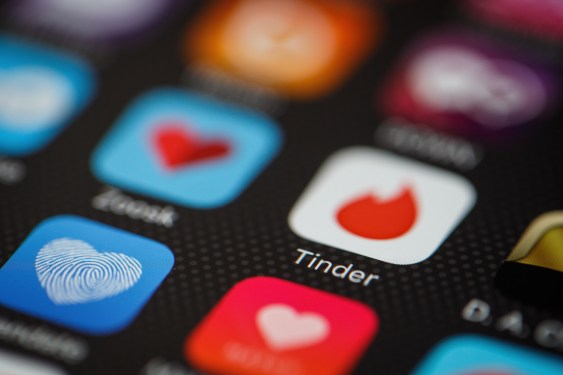 The "Tinder" app logo is seen amongst other dating apps on a mobile phone screen.