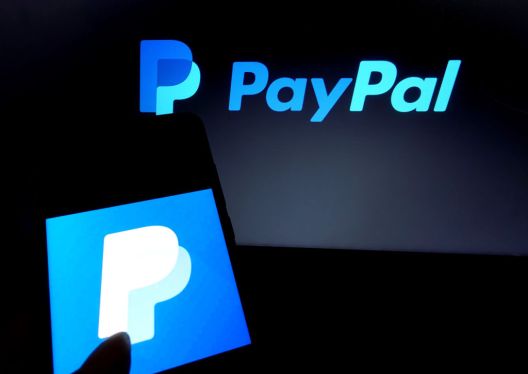 In this photo illustration a famous online transfer application PayPal logo seen displayed on a smartphone.