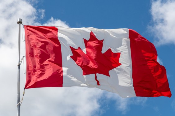 Canada flag waving against a blue sky