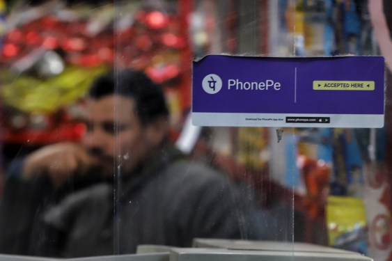 PhonePe Digital Wallet Platform And Online Payment Sticker is pasted on the glass at a Grocery Shop