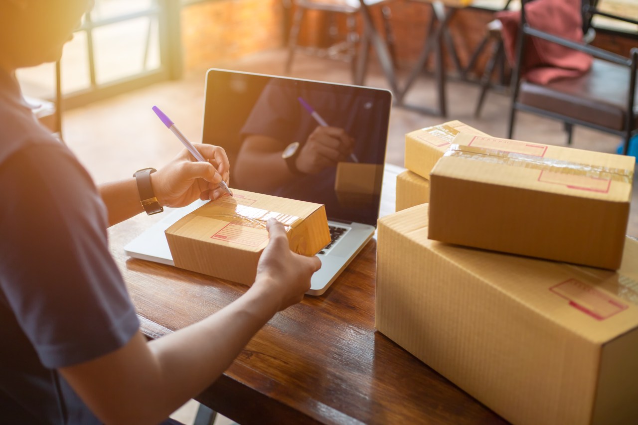 Online shopping young start small business in a cardboard box at work. The seller prepares the delivery box for the customer, online sales, or ecommerce.