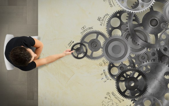 Overhead shot looking down on a man sorting gears and setting organizational priorities