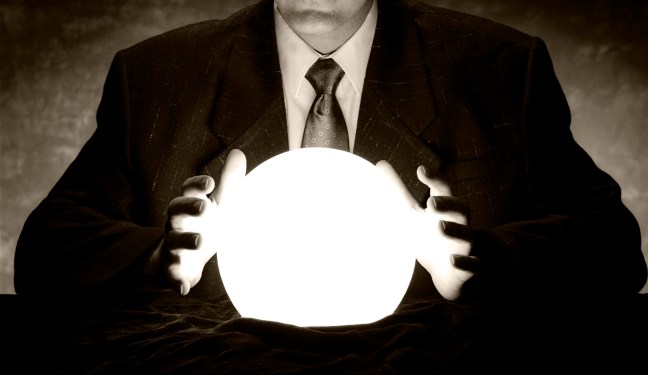 A businessman is consulting a crystal ball to foretell the future.