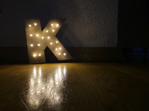 Illuminated K Letter In Darkroom