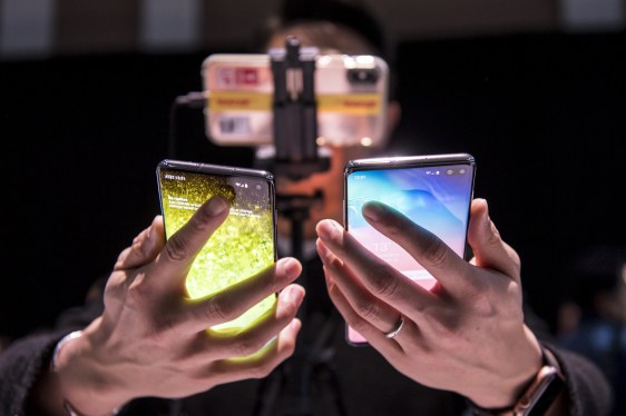 A person holding up two Samsung phones, one in each hand, at a Samsung event in 2019.