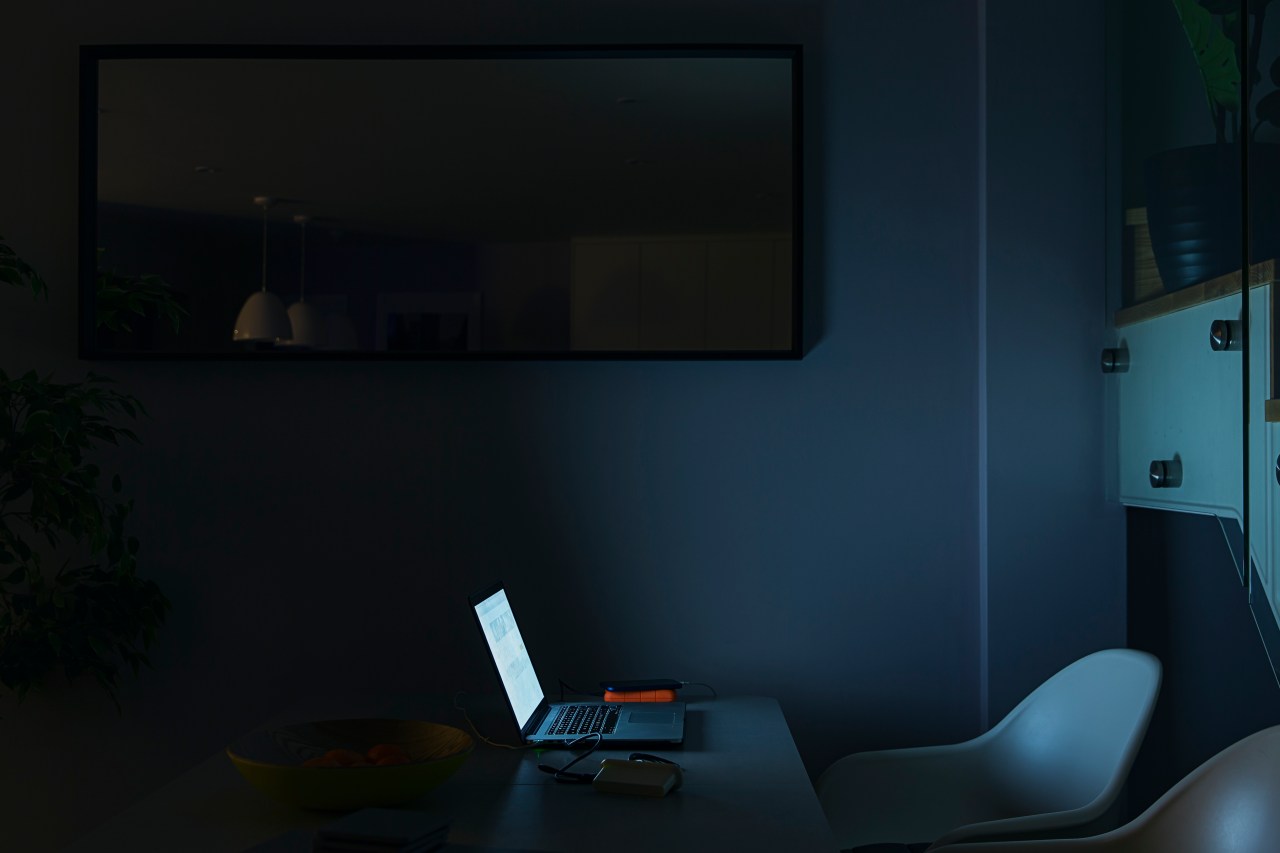 A single lit-up laptop in a dark room.