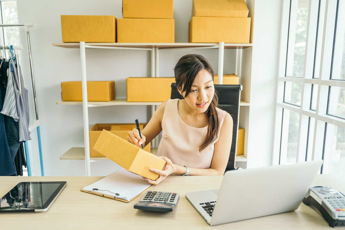 Young business woman working at home office with online marketing in laptop, used in post about Una Brands