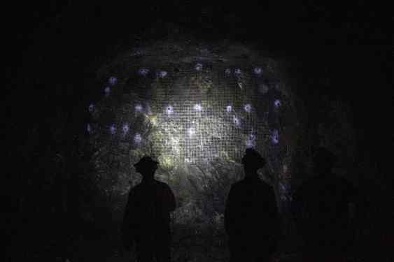 Miners standing in front of a wall in a nickel mine.