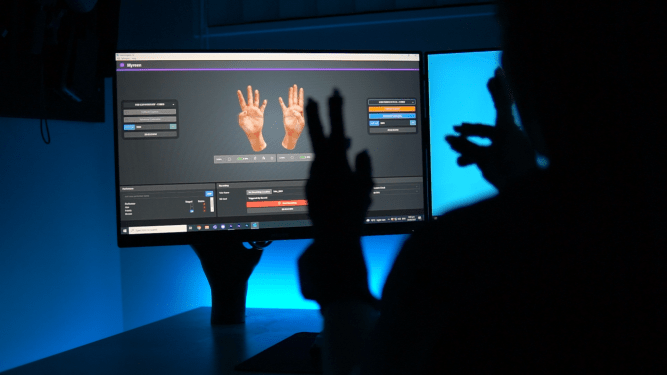 hands wearing stretchsense hand motion capture glove and the animation behind them