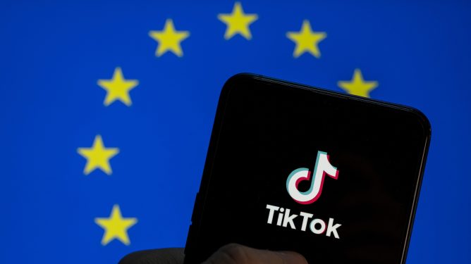 TikTok logo seen on an Android mobile device screen with the European Union (EU) flag in the background.