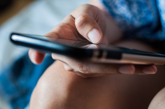 A close up of the hands of a young woman using a mobile phone, used in post about Salmon