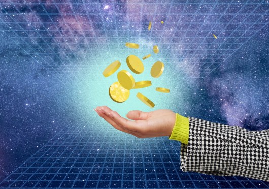 An image of A collection of gold coins hove above a human hand in a virtual space