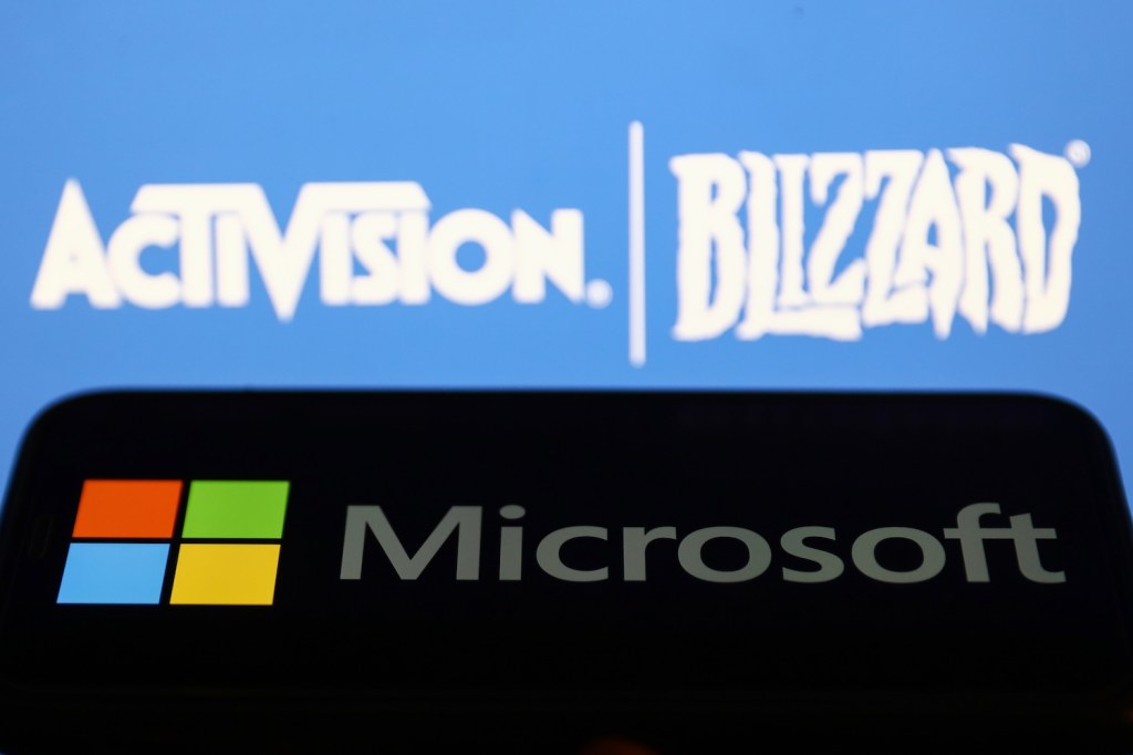 Microsoft logo displayed on a phone screen and Activision Blizzard logo displayed on a screen in the background are seen in this illustration photo taken in Krakow, Poland on July 17, 2023. (Photo by Jakub Porzycki/NurPhoto)