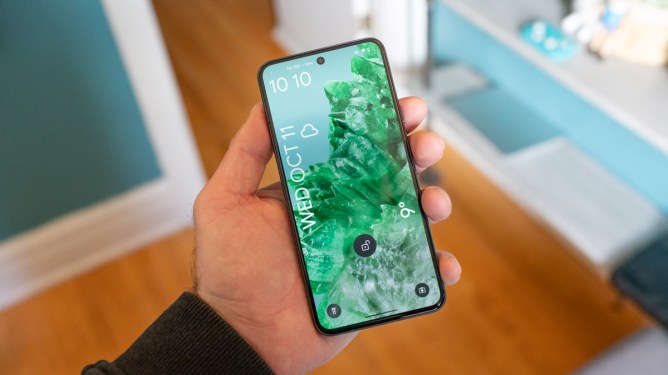 Google Pixel 8 held in hand, showing the lock screen