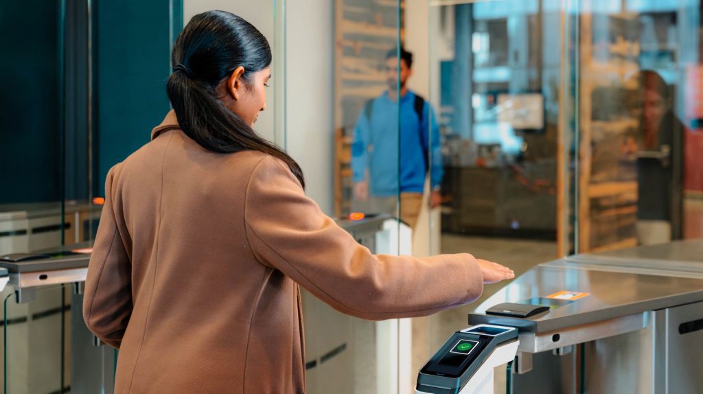 Amazon One Enterprise; woman scanning palm to enter/exit