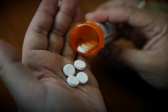 pills from a medication bottle being shaken into a hand