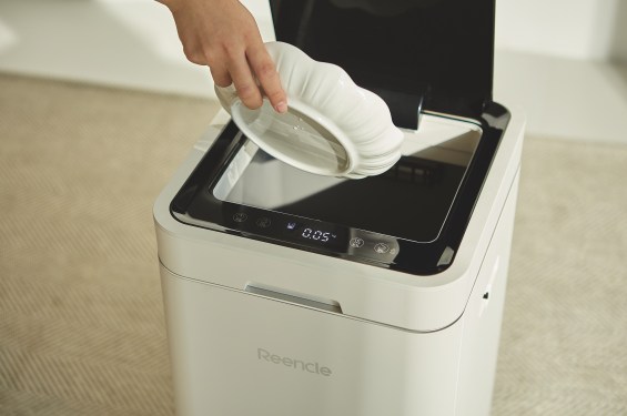 A promotional image shows a hand holding a dish above a Reencle brand smart composting device, which the company named Reencle Gravity.