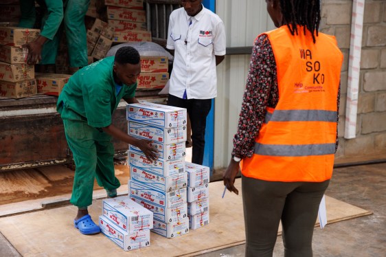 An employee loads boxes of soap onto a truck