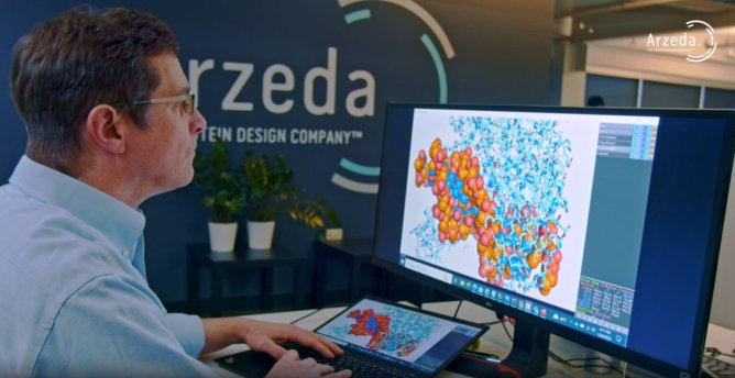 Man working at Arzeda, sitting in front of large computer monitor