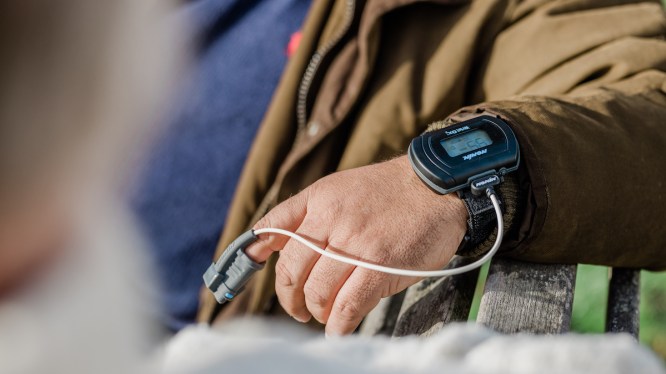 patient wearing finger to wrist-worn monitor