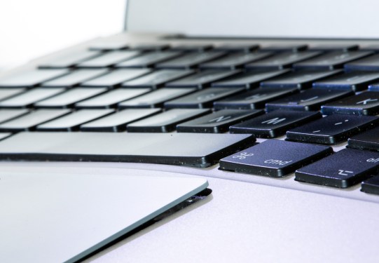 A Macbook Air with an inflated battery that has pushed the trackpad and keyboard apart.