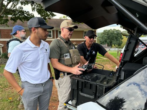 Image of Asheville law enforcement and a member of Paladin's team remotely flying a drone