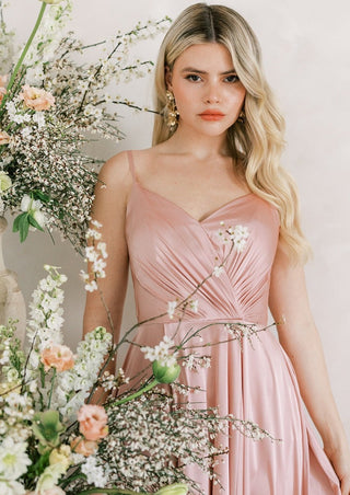 Blush satin bridesmaids maxi dress with pleated bodice and spaghetti straps and full skirt.