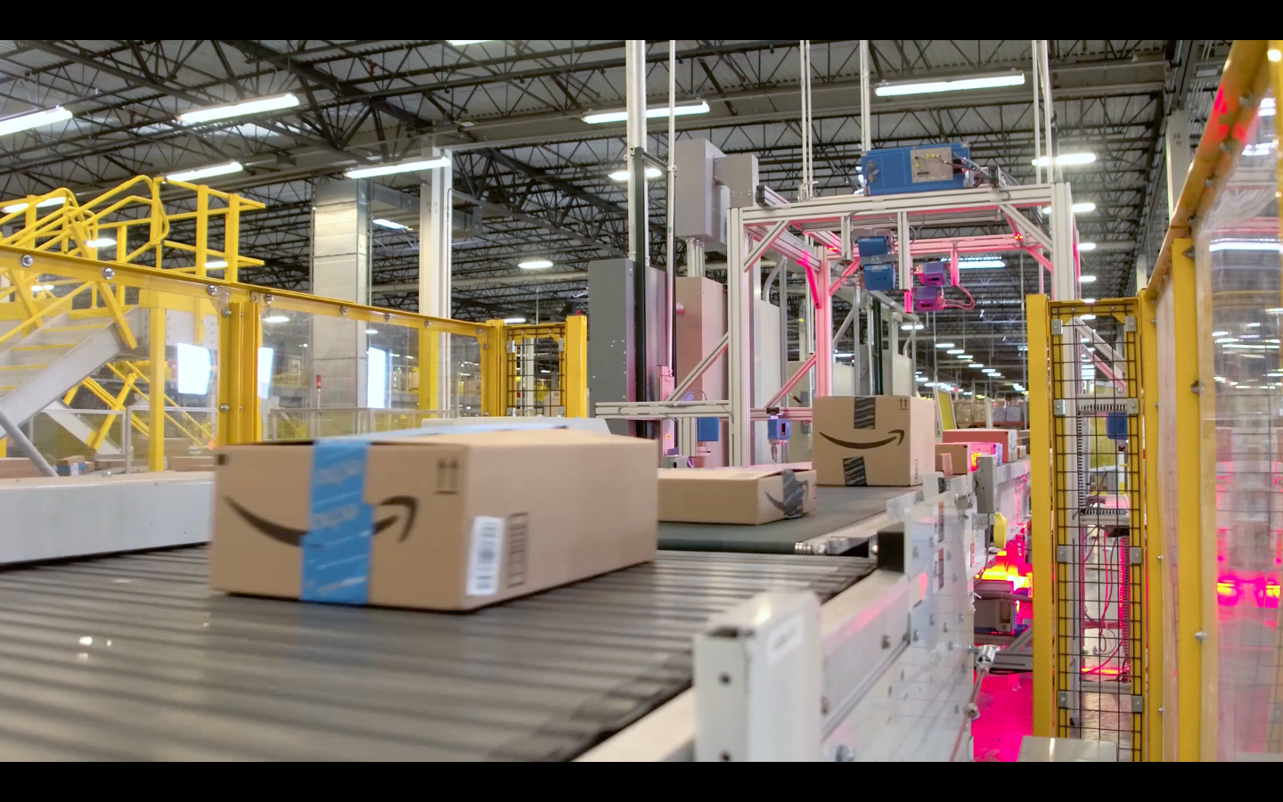 A conveyor belt in an Amazon fulfillment center warehouse moves boxes