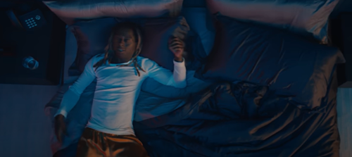 Lil Wayne lying on a bed