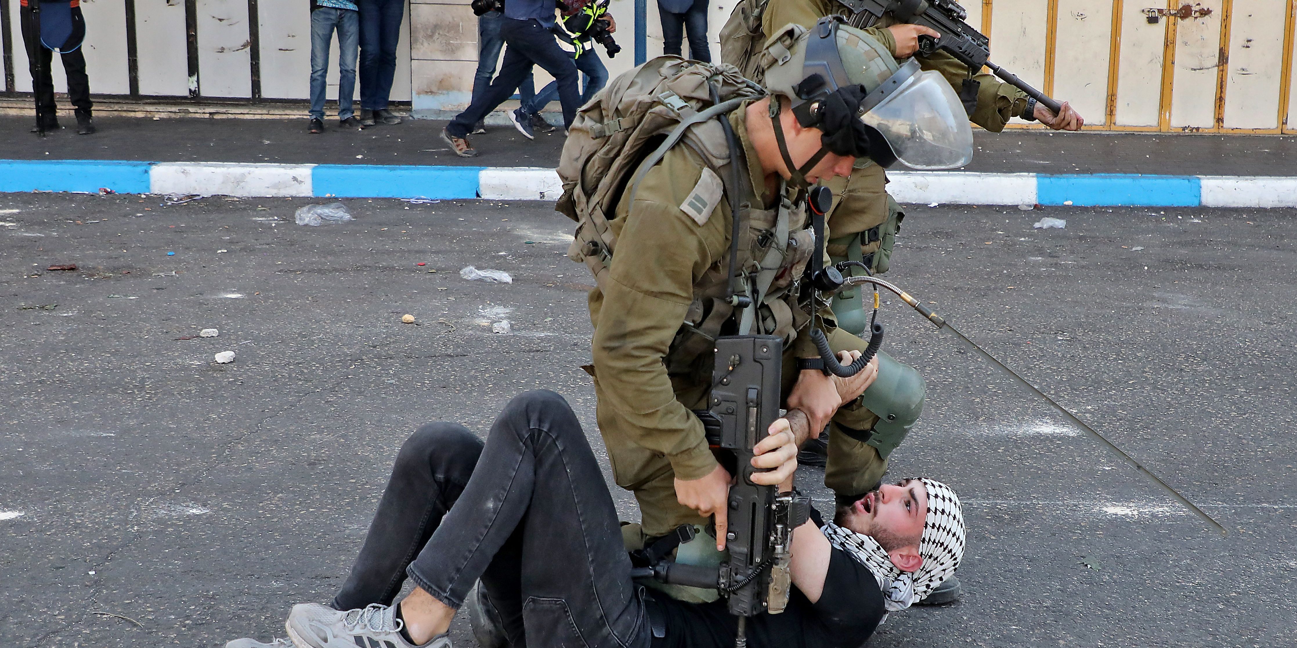 An Israeli soldier kneels on the chest of a Palestinian protester on the streets of Hebron, in the occupied West Bank, in October 2022.